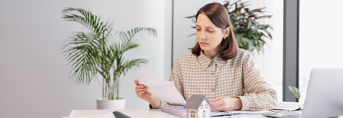 Mujer revisando documentos para comprar casa representando el acceso de las mujeres al financiamiento inmobiliario y la construcción de patrimonio propio en México