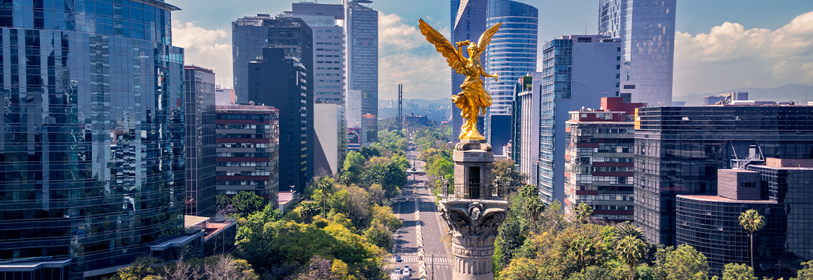Vista del Ángel de la Independencia en Ciudad de México rodeado de edificios corporativos y vialidades principales, ejemplo de infraestructura urbana que influye en la plusvalía inmobiliaria.